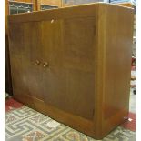 A medium to light oak side cupboard in the Heals manner, enclosed by a pair of segmented veneered