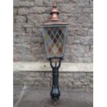 A Victorian street lantern the copper square tapered hood with raised finial and enclosed by