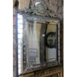 A Venetian wall mirror, the deep stepped cushioned frame with segmented etched floral plates beneath