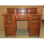 An Edwardian walnut kneehole twin pedestal writing desk fitted with an arrangement of nine