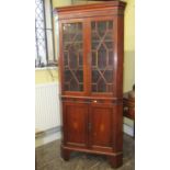 A Georgian oak freestanding corner cupboard, the lower section enclosed by two panelled doors, the