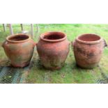Four old weathered terracotta preserve jars, three with moulded handles and incised detail
