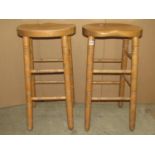 A set of four good quality contemporary stained beechwood high stools with saddle shaped seats