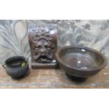 An antique turned stem bowl, a 19th century iron cauldron and a carved oak boss, with grotesque mask