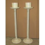 A pair of floorstanding pricket candlesticks, with spiral twist stems, domed disc shaped platform