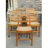 A set of seven vintage stained beechwood single chairs with simple rail backs over dished slatted