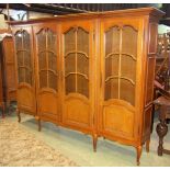 A large medium oak floorstanding, four door shallow breakfront bookcase, partially glazed with