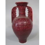 A large early 20th century two handled vase with ox-blood type glazed decoration and moulded