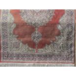 Full pile eastern carpet with central blue medallion upon a washed red ground, 320 x 210cm