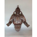 A carved 19th century oak wall piece, in the form of a jester, his hands outstretched perhaps to