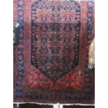 Persian rug with central blue geometric medallion decoration upon a washed pink ground, 230 x 135cm