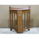 An arts and crafts oak breakfront floorstanding umbrella stand, with canted open slatted sides