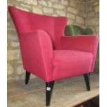 A contemporary but retro style wing armchair, with upholstered finish and ebonised supports