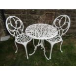 A cream painted cast aluminium three piece garden terrace set comprising circular top table and a