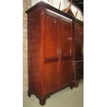 An Edwardian mahogany wardrobe in the Georgian style, with stepped and moulded pediment over a