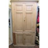 A substantial 19th century stripped pine two sectional floorstanding corner cupboard enclosed by two