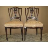 A pair of Edwardian occasional chairs with inlaid detail and shield shaped backs with pierced vase