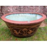 A large oriental planter/fish bowl of oval form, matt glazed with slipware, floral and bird