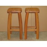 A pair of heavy contemporary oak high stools, the square moulded seats raised on shaped supports