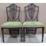 A pair of late Victorian mahogany dining chairs in the Hepplewhite style with shield shaped and