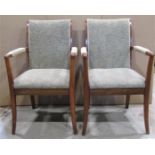 A pair of mid-20th century teak framed open armchairs, with floral patterned upholstered seats,