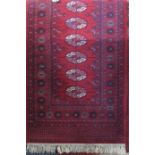 Pair of long Bokhara runners with typical geometric medallion decoration upon a red ground, each 330