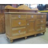 A Victorian stripped pine Lancashire dresser, the shallow raised and shaped back supporting a narrow