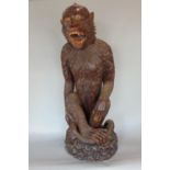 A high quality carved timber figure of an ape, the creature in seated upright pose with curled tail,