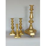 A large turned brass floor candlestick or Prickett stick, 48cm high, together with a further pair of