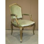 A futile with upholstered seat, shield shaped panelled padded back and arms, within a gilded