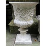 A campana shape composition stone garden urn with flared rim, raised relief scrolling foliate
