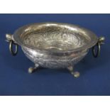 Good antique probably Indian silver twin handled dish, the bowl embossed with various foliage,