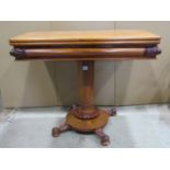 A Victorian mahogany fold over top tea table, with moulded scrolled frieze, raised on a central