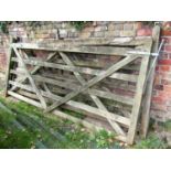 Two similar weathered soft wood five bar field gates with diagonal bracings and galvanised