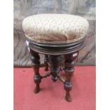 A late 19th century piano stool with circular revolving and rising seat, raised on four turned