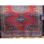 Full pile Persian village carpet with various blue and pink ,medallions upon a red ground, 310 x