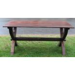 A hardwood garden/tavern table of rectangular form with plank top raised on x framed supports united