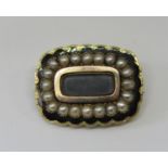 Early Victorian yellow metal mourning brooch with split pearl and black enamel decoration, inscribed