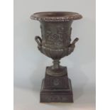 Cast bronze twin handles campania urn, cast with a putti battle scene, on a stepped square base