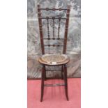 A regency beechwood child's correction chair, with simulated bamboo mouldings and oval cane panelled