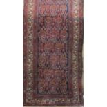 A good long Persian runner with geometric paisley decoration upon a blue and red ground, 500 x 100cm