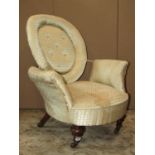 A Victorian low drawing room chair, the upholstered iron frame with cushioned cameo shaped back,