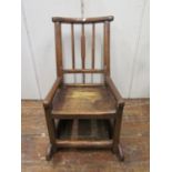 An 18th century primitive child's rocking chair, principally in oak with simple stick-back