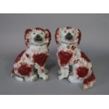 A pair of 19th century Staffordshire spaniels with red painted patches and separate forelegs (both