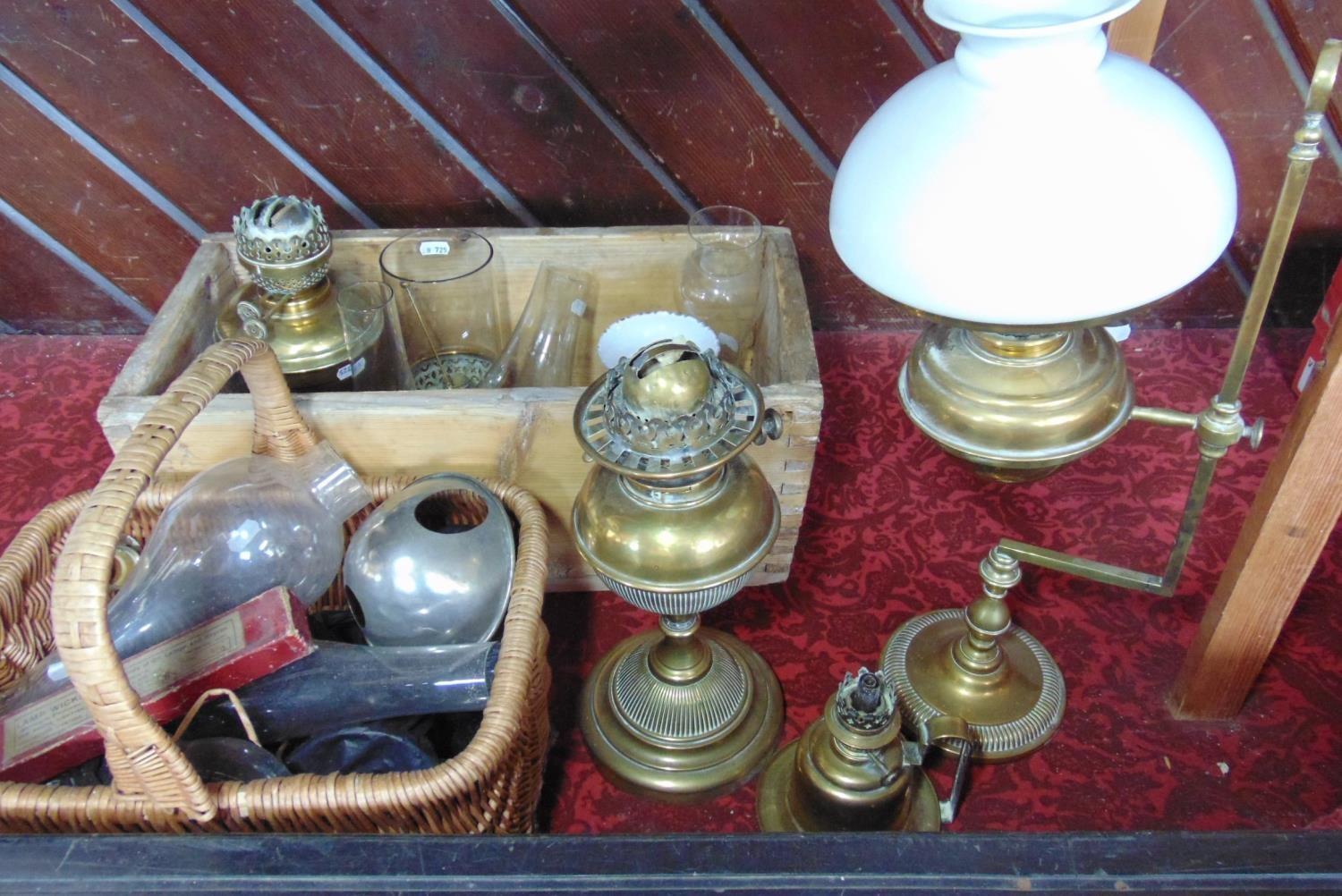 A Victorian brass students oil lamp on adjustable frame, a further Victorian brass oil lamp, two