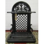 A Victorian cast iron two divisional umbrella stand with arched and pierced lattice back and