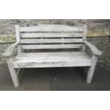 A weathered teak Swan Hatherley two seat garden bench with slatted seat and back, 132 cm long