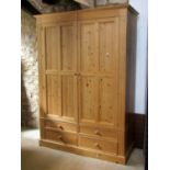 A Victorian style stripped pine wardrobe enclosed by a pair of three quarter length quarter