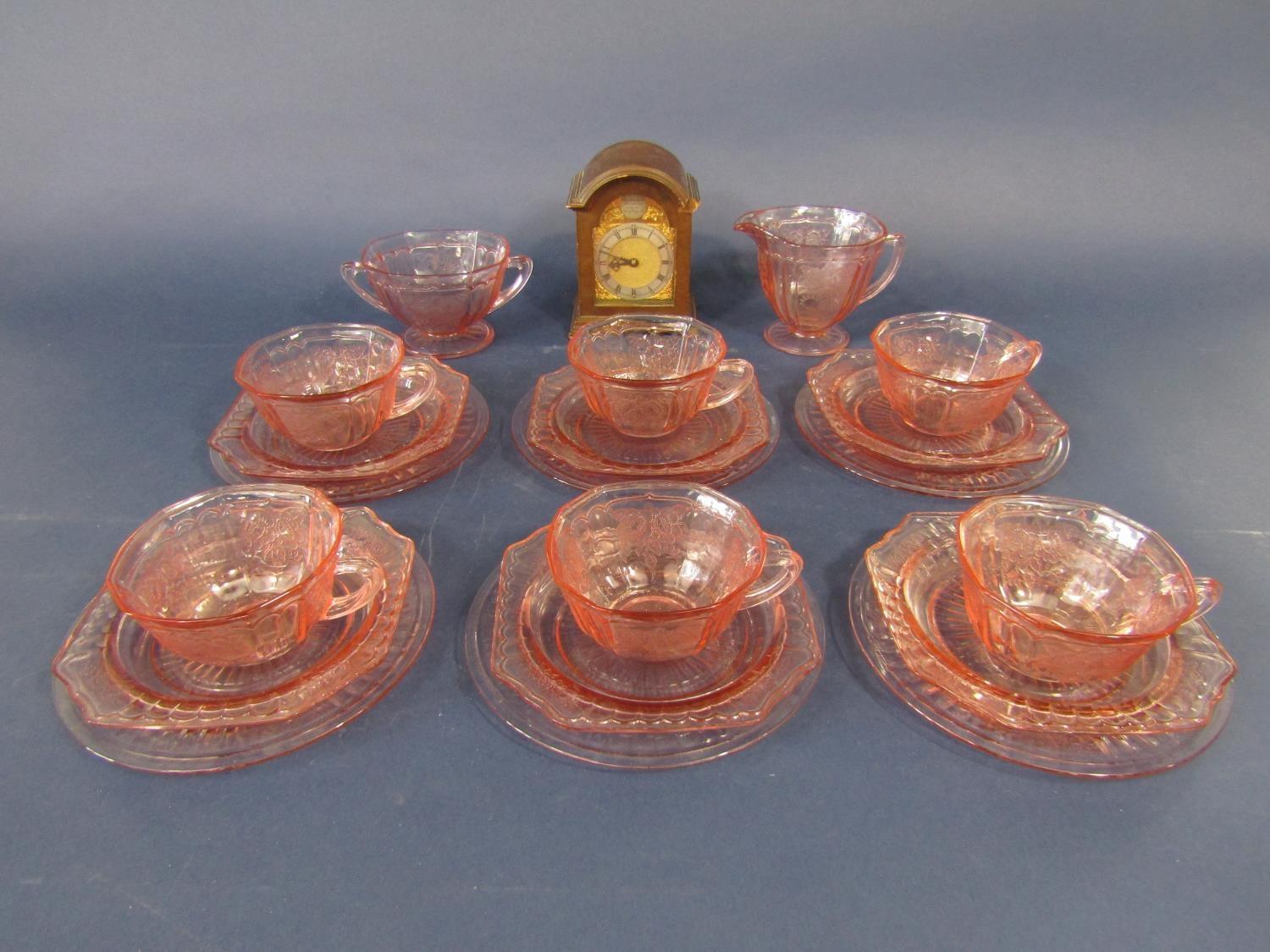 A collection of art deco pressed glass tea wares, together with a miniature bracket type clock (a