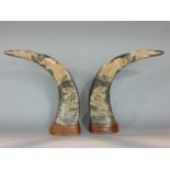 A pair of mounted buffalo horns with engraved dragon and tiger detail